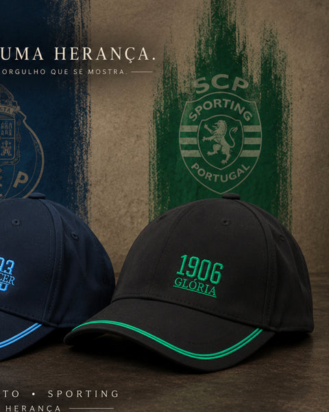 Three Sporting Portugal baseball caps displayed on a dark wooden surface against a textured backdrop. The center cap is black with a green embroidered '1906 GLORIA' logo and a green piping accent along the brim.