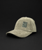 A light olive green corduroy baseball cap with a black embroidered square patch on the front that reads 'LIVE MORE WORRY LESS'. The cap is photographed on a solid black background.