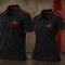 Two black short-sleeve polo shirts displayed on invisible mannequins against a textured brown and red background. Both shirts feature red piping along the collar and sleeve cuffs, and a red embroidered logo on the left chest reading '1904 EST.