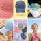 A six-panel collage showcasing children's baseball caps in various colors and lifestyle settings: a close-up of a pink cap, a blue cap on a yellow background, a green cap on a rainbow blanket in a car, a light blue cap being held by a child on a beach, a group of caps with daisies on a lavender background, and a smiling girl wearing a pink cap outdoors.