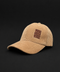 A tan corduroy baseball cap with a small brown embroidered patch on the front that reads 'LIVE MORE WORK LESS' in reverse, set against a solid black background.