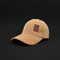 A tan corduroy baseball cap with a small brown embroidered patch on the front that reads 'LIVE MORE WORK LESS' in reverse, set against a solid black background.